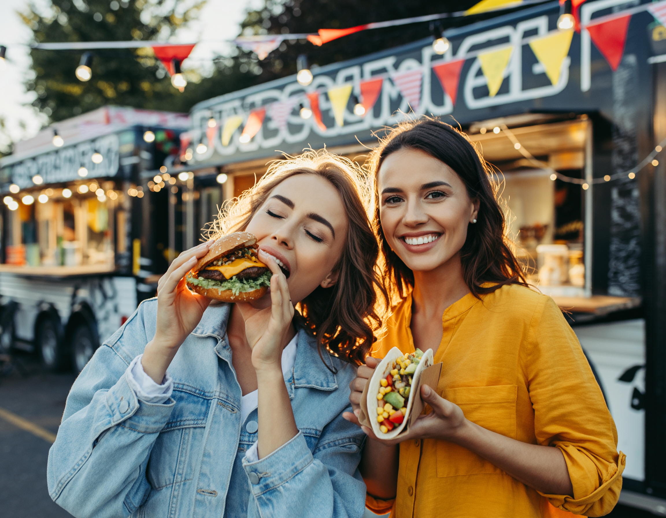 Firefly_Two young attractive women enjoying street food at an outdoor spring festival. One wo 87447